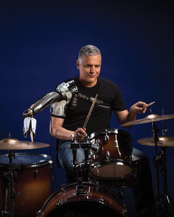 Drummer performing with a shoulder-mounted robotic arm